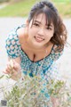 A woman in a blue and white polka dot dress posing for a picture.